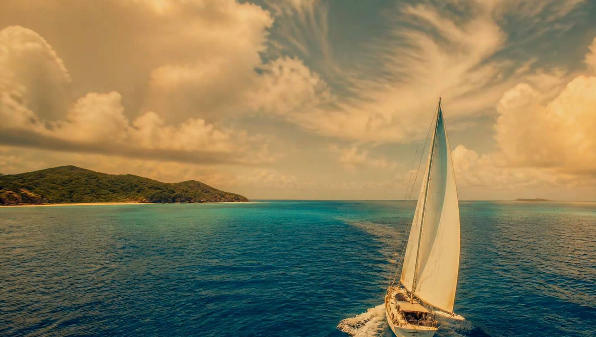 A vibrant tropical sea with turquoise water, a shining sun, and a wide bright horizon